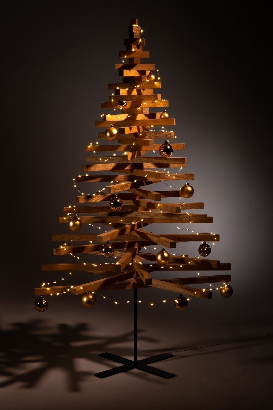 hölzerner weihnachtsbaum dekorieren weihnachtskugeln gold